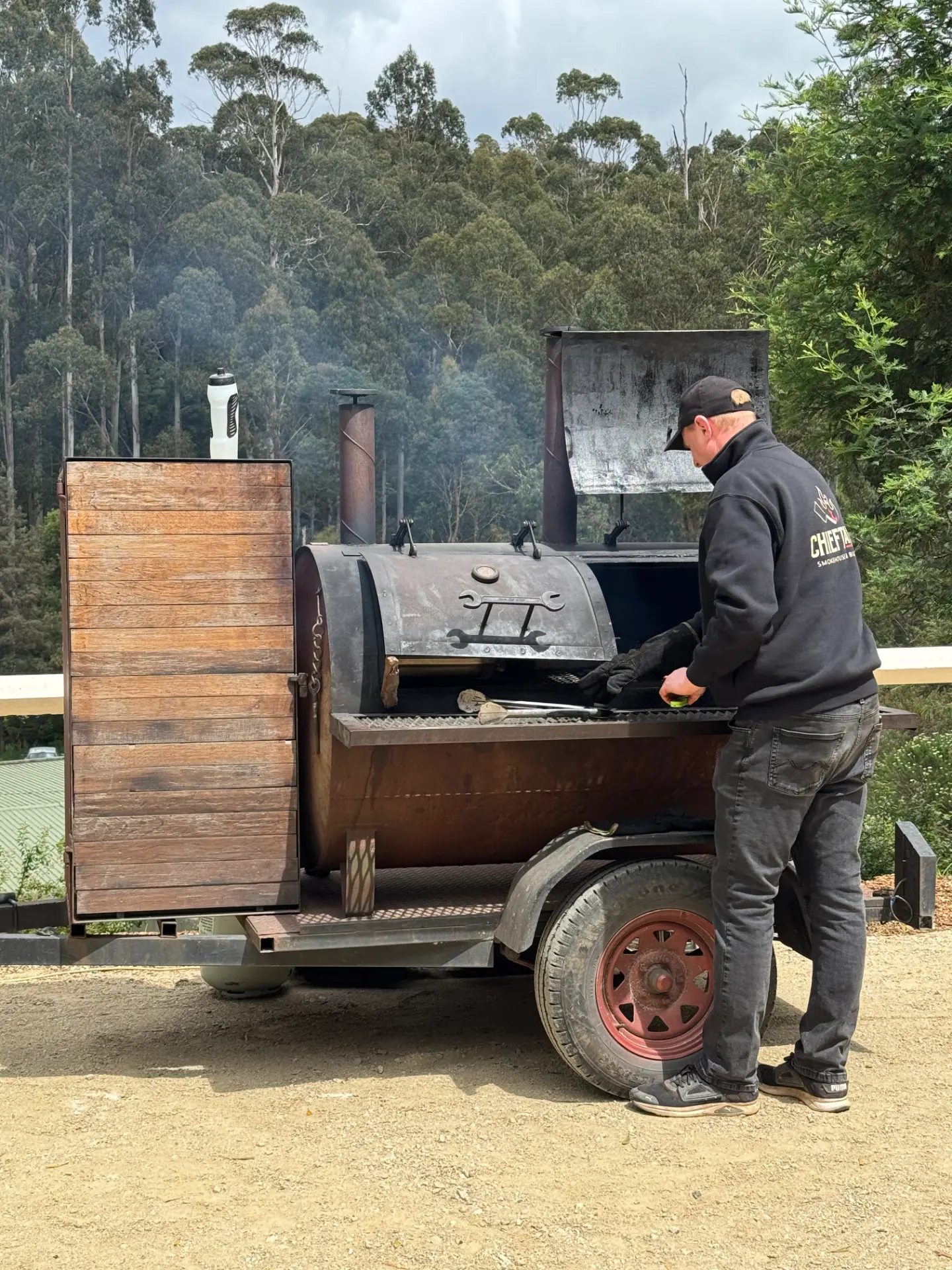 Chieftains pitmaster tending a large outdoor smoker at a public event