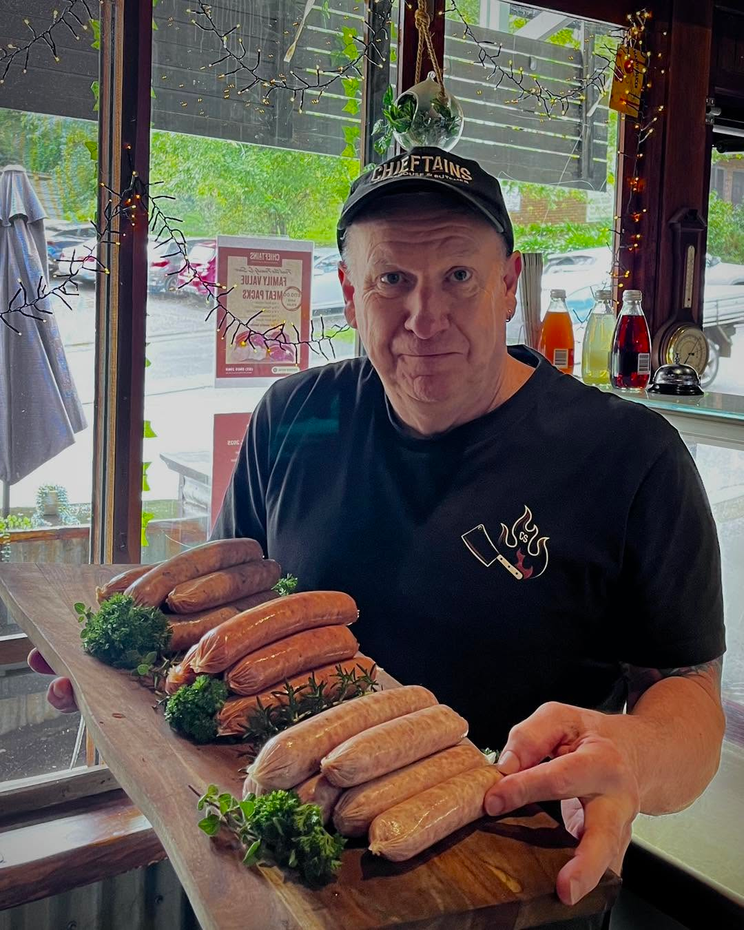 Chieftains chef presenting premium handmade sausages on a wooden board